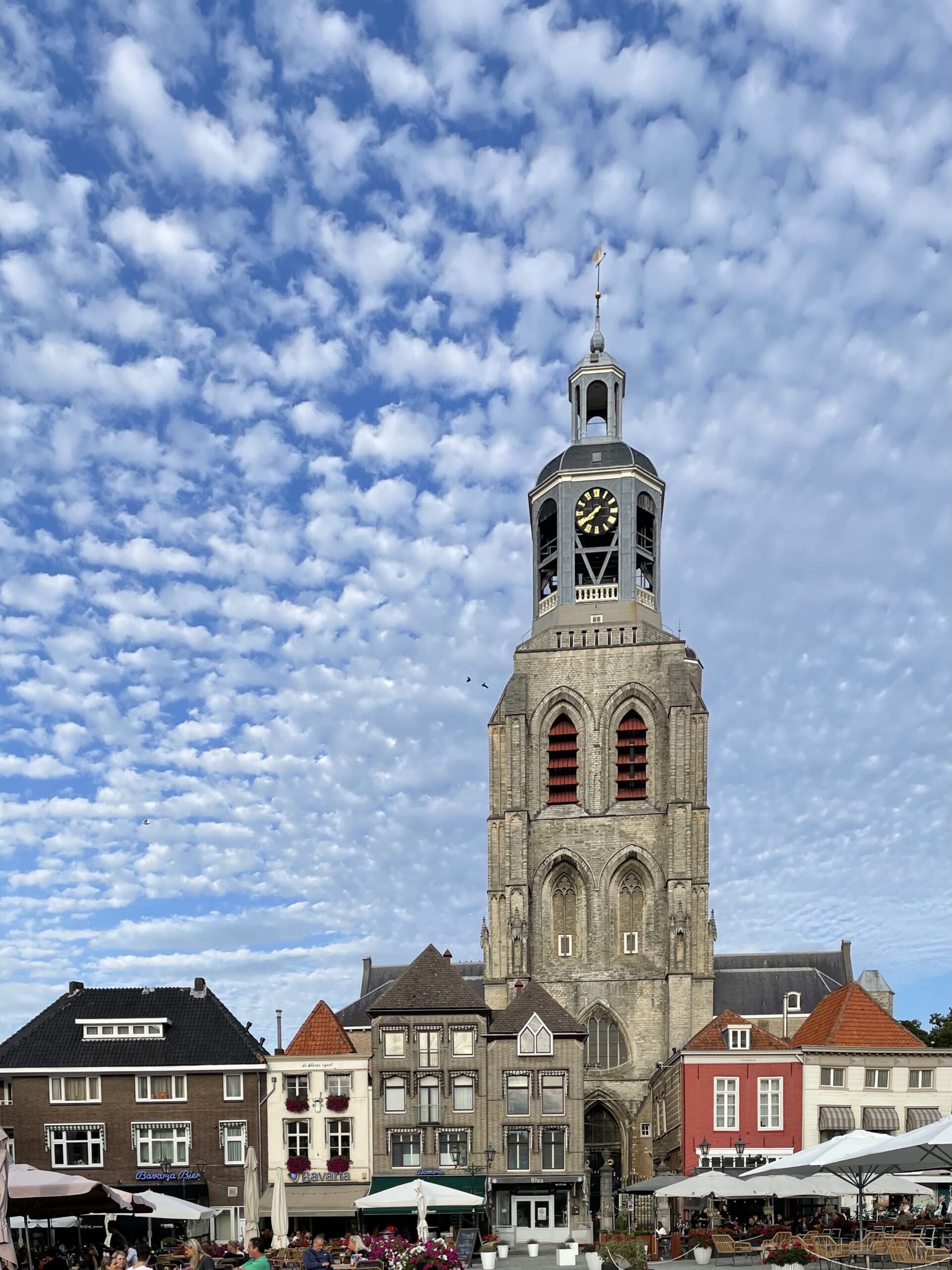 Kerktoren (Peperbus) met wolkenhemel en omliggende gebouwen Bergen op Zoom