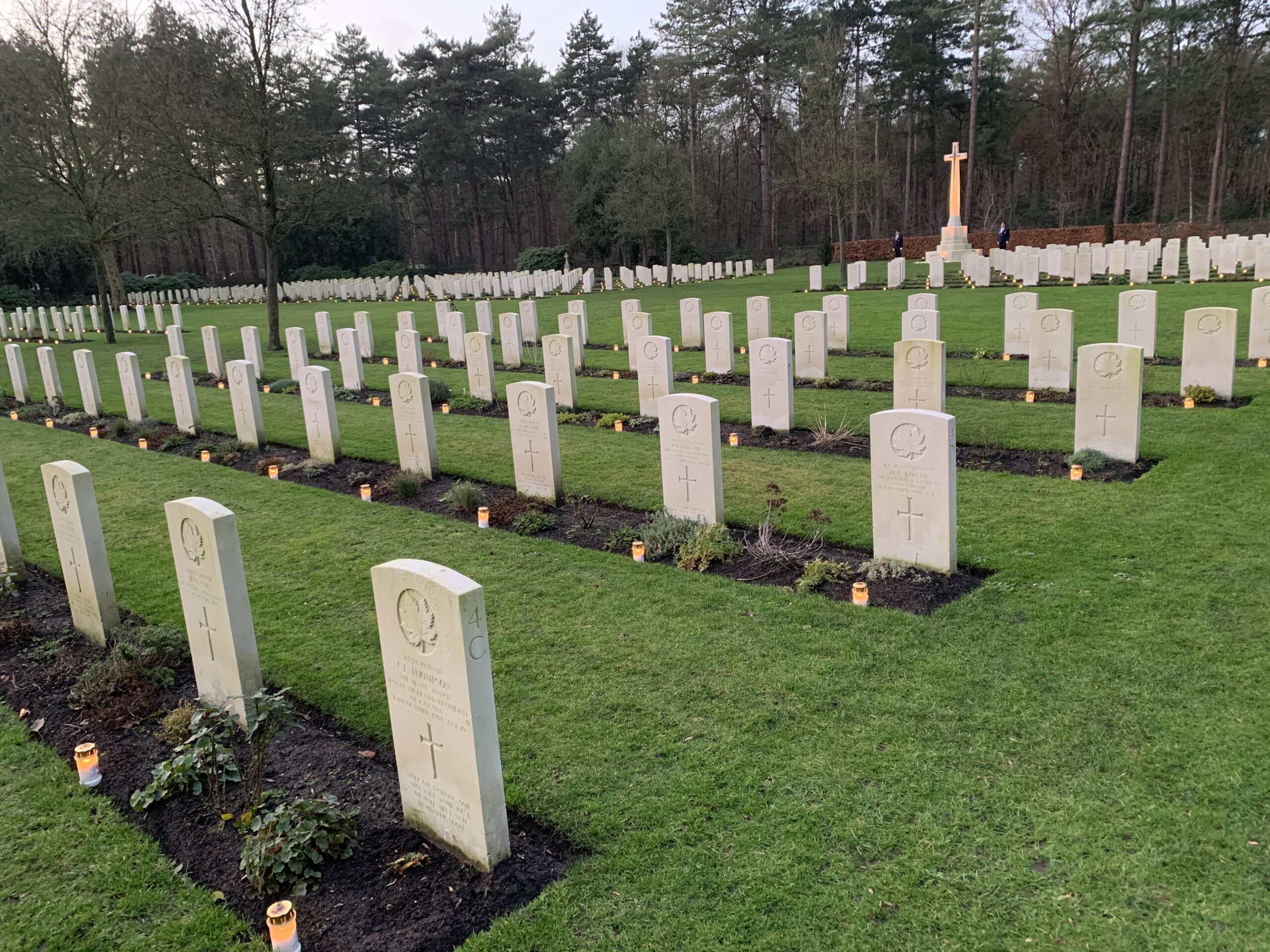 Oorlogsgraven in groene bosrijke omgeving met kaarsen