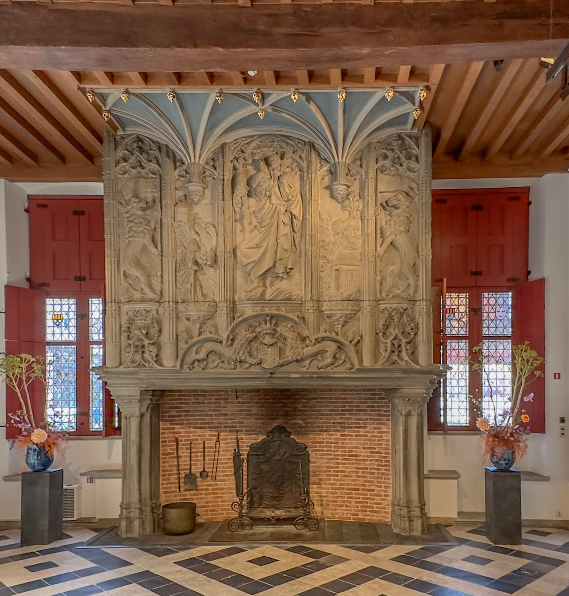 Historische open haard met gedetailleerd houtsnijwerk.