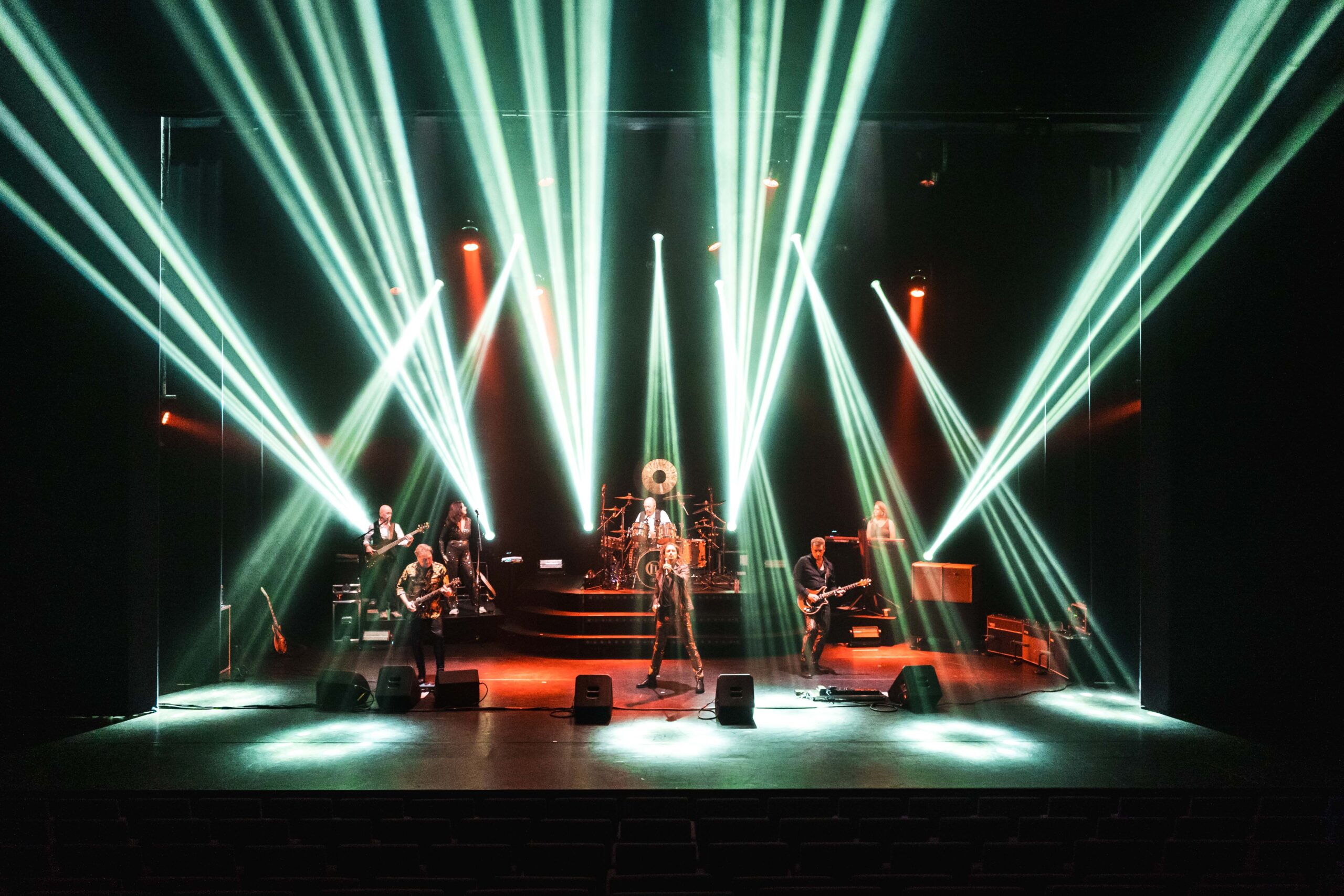 Muzikanten optreden op podium met kleurrijke verlichting
