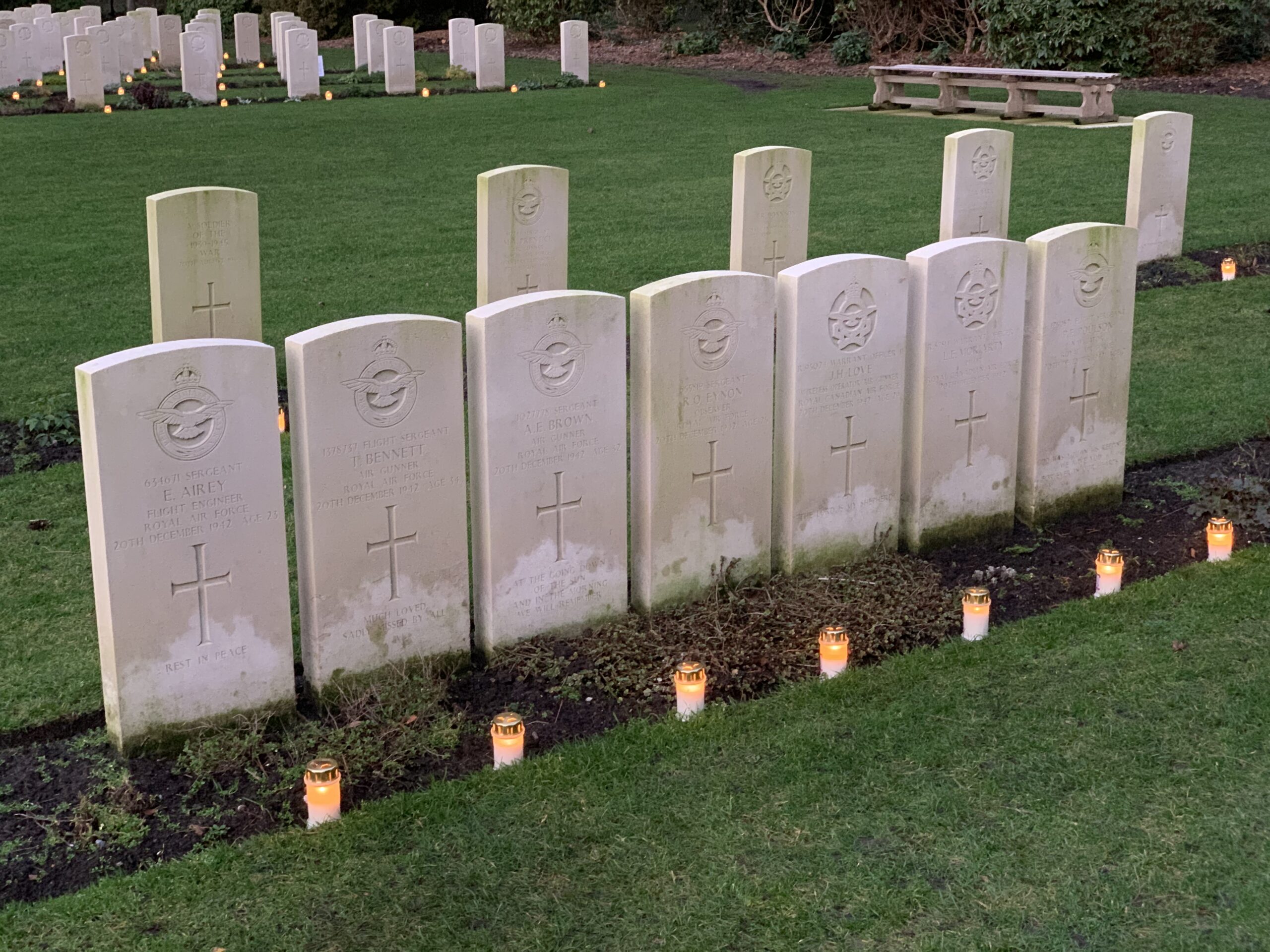 Oorlogsgraven met kaarsen op herdenkingsplaats bij avond