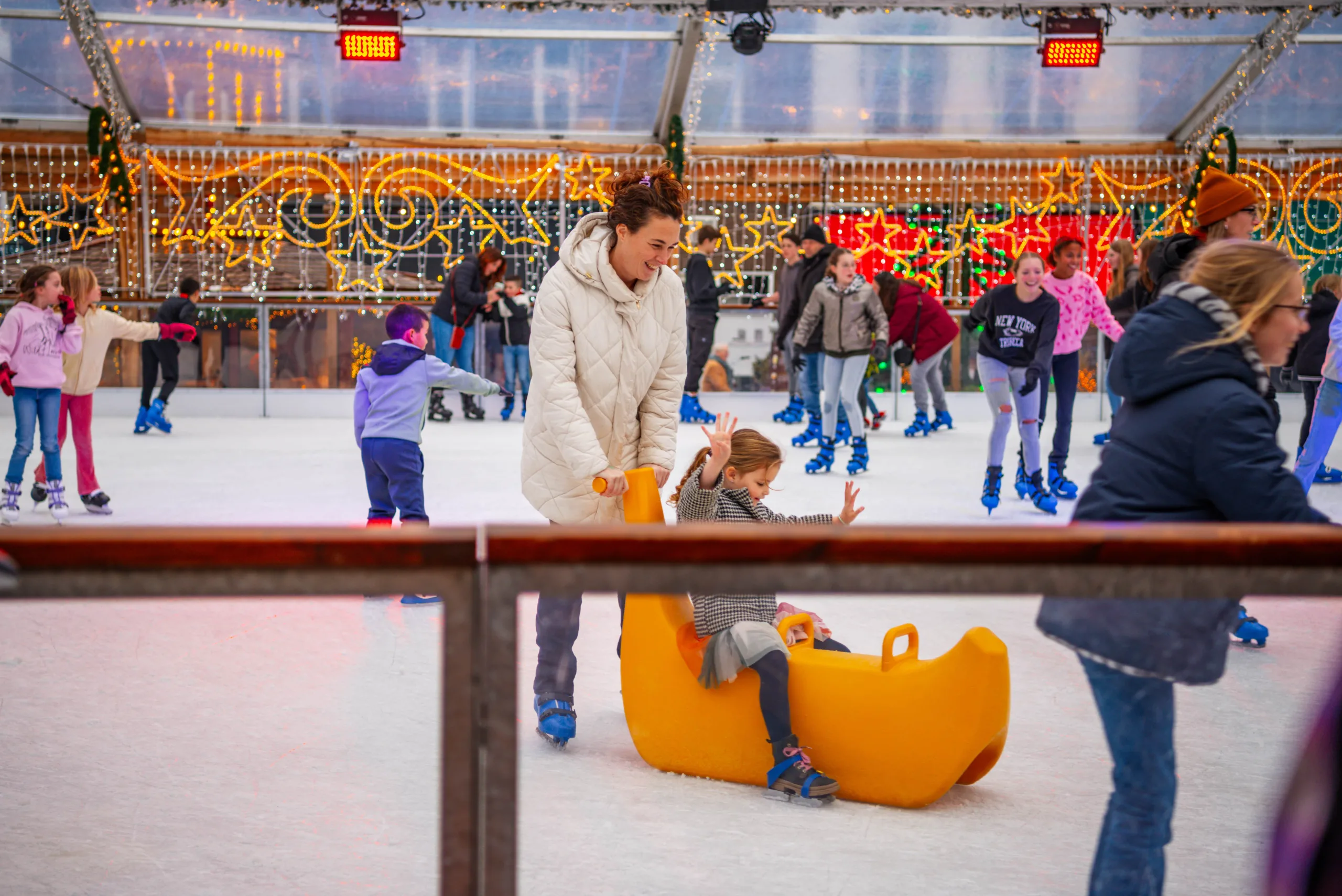 Moeder en kind schaatsen op een ijsbaan