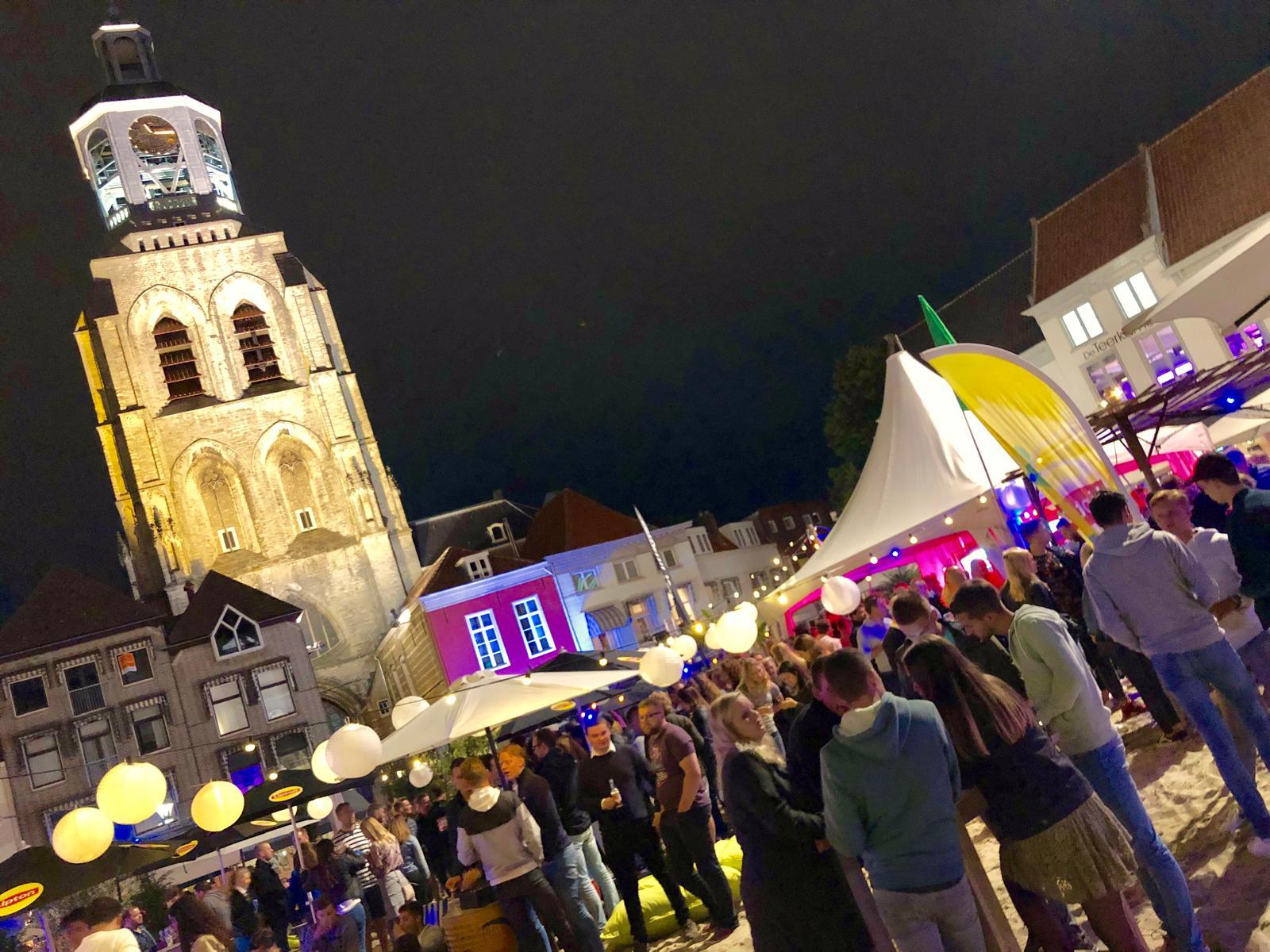 Drukke nachtmarkt op Grote Markt in Bergen op Zoom met Peperbus