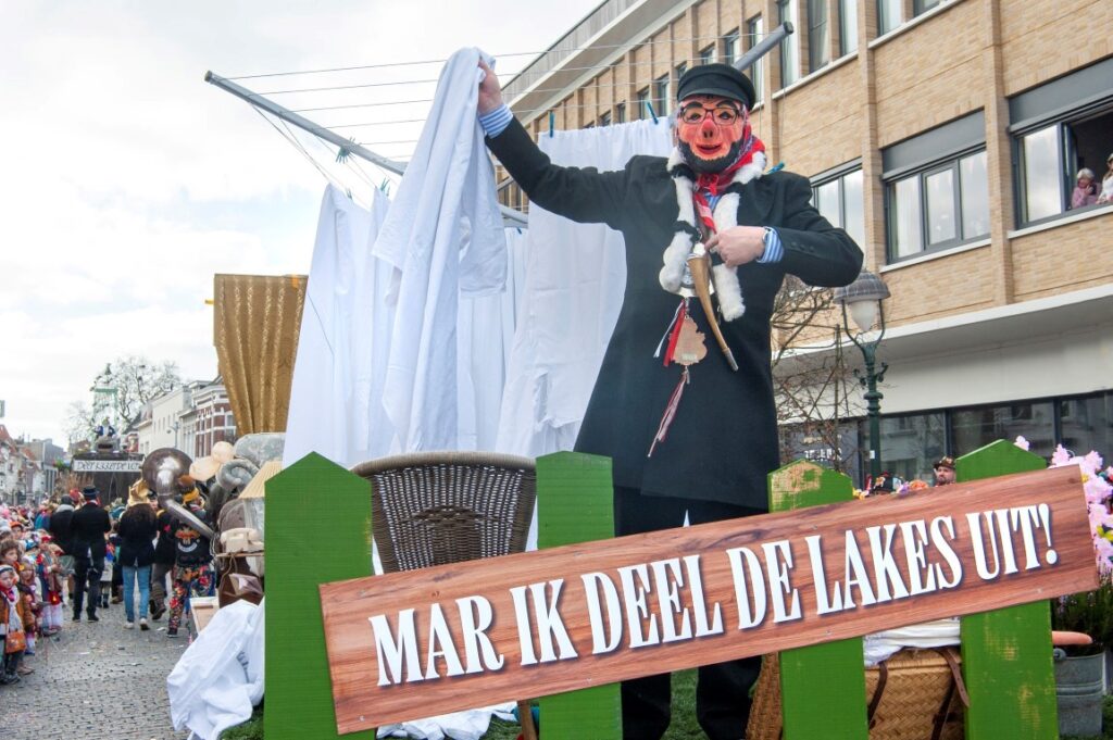 Carnavalsvierder op parade met spandoek straatfeest