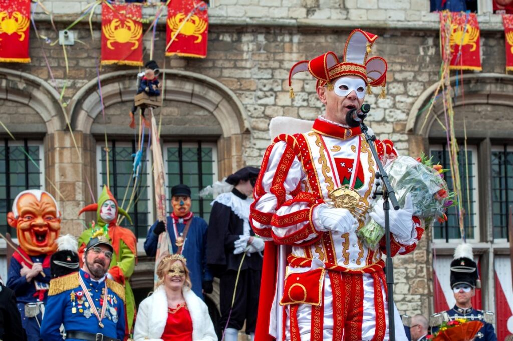 Prins carnaval spreekt tijdens kleurrijk carnavalsfeest in kostuum.