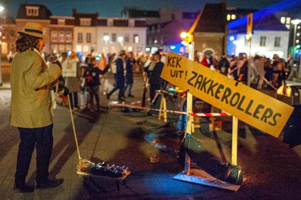 Man met hoed bij nachtelijke straatkunst evenement