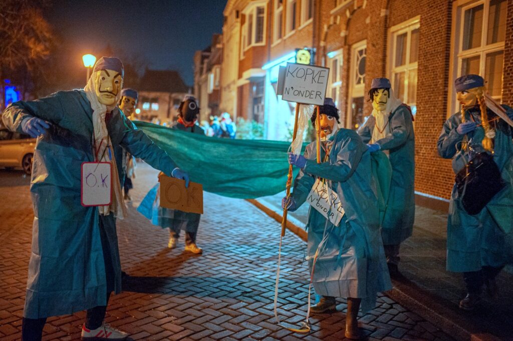 Mensen in kostuums op straat 's nachts - Vastenavend