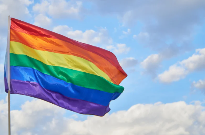 Regenboogvlag wappert tegen blauwe lucht - Bergen op Zoom