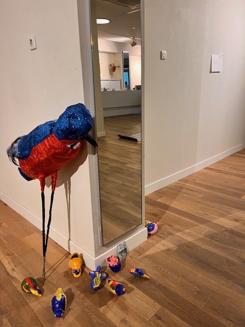 Kleurrijke papegaai decoratie naast een spiegel - Bergen op Zoom