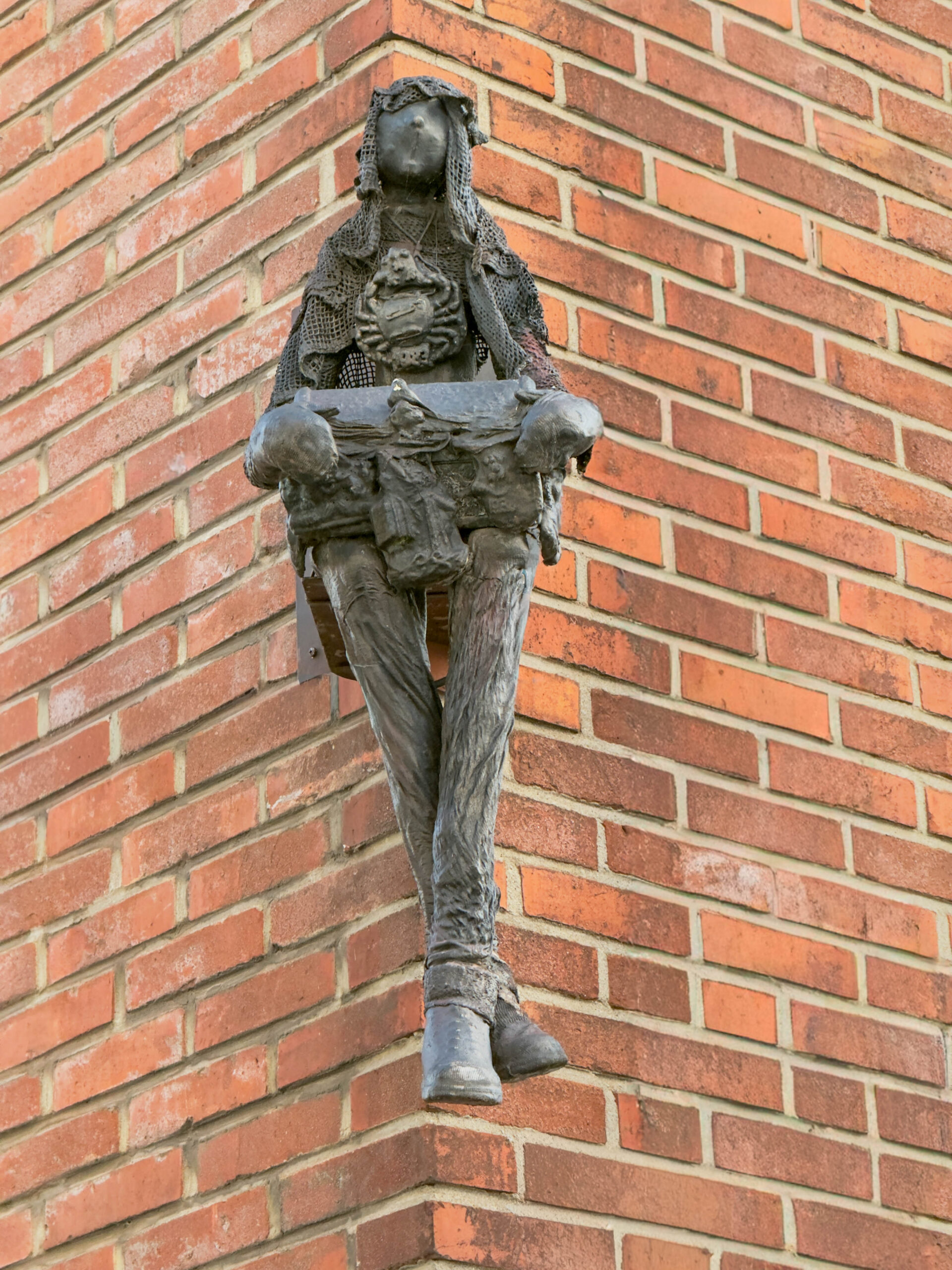 Baksteenmuur met opvallende sculptuur aan gevel - Bergen op Zoom